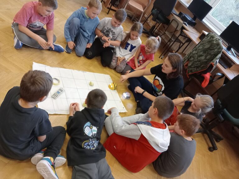 Dzieci biorące udział w projekcie Bee-Bot – Więzień labiryntu podczas pracy z robotem edukacyjnym.