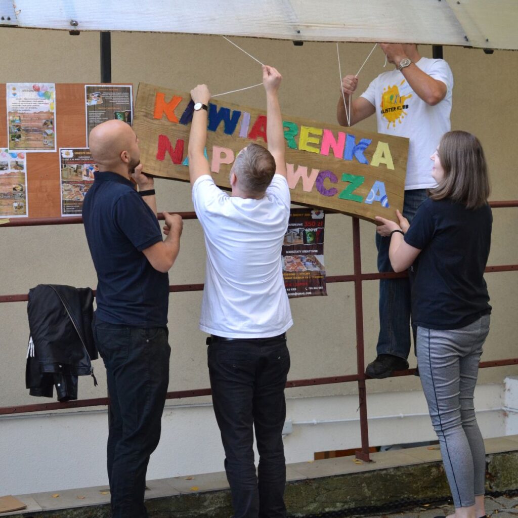 Wolontariusze montują kolorowy napis wydarzenia podczas przygotowań do imprezy