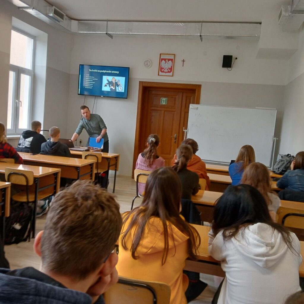 Prowadzący omawia zagadnienia ekonomiczne podczas lekcji dla uczniów
