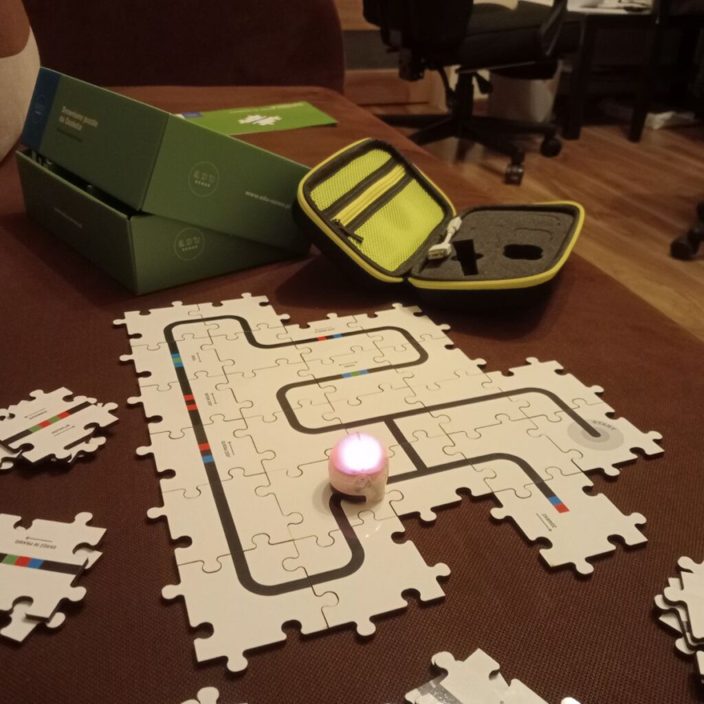Robot Ozobot porusza się po ułożonej z puzzli planszy do nauki programowania