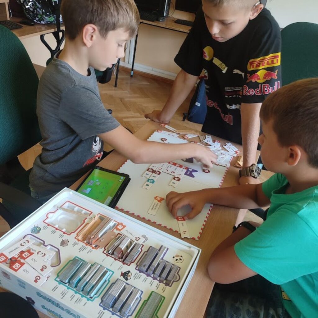 Grupa dzieci rozwiązuje zadania programistyczne przy użyciu gry Scottie Go