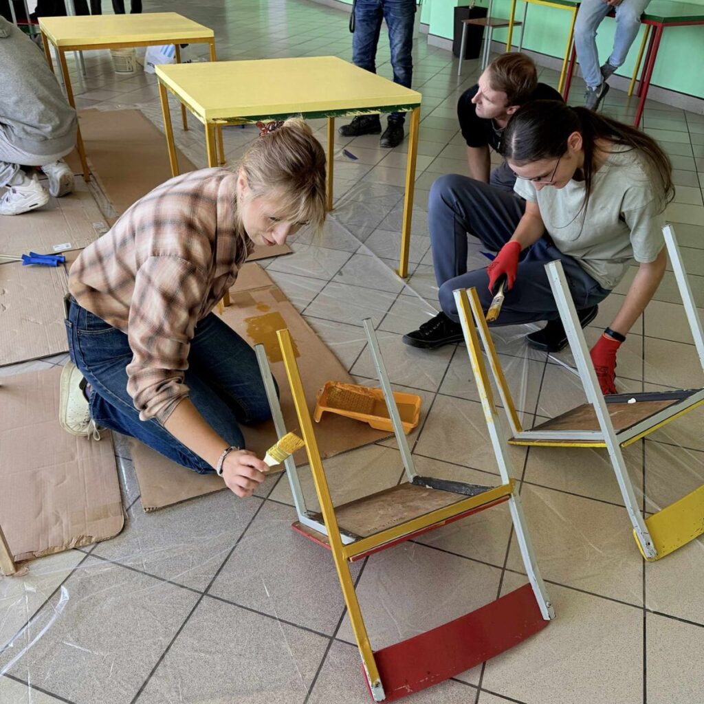 Uczestnicy projektu „Fabryka Dobrego Klimatu” podczas odnawiania i malowania krzeseł