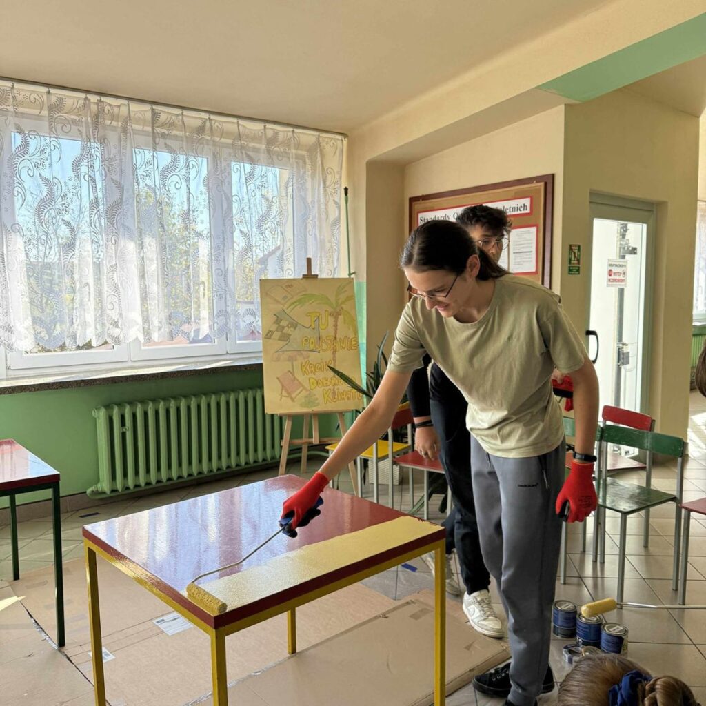 Uczestnicy projektu „Fabryka Dobrego Klimatu” podczas malowania szkolnego stołu